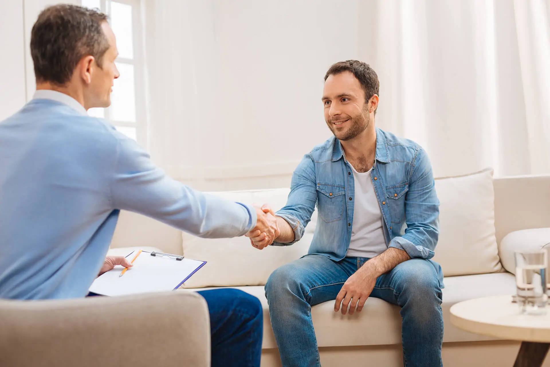 Man shakes therapist’s hand, recognising his courage to confront challenges in eating disorder therapy