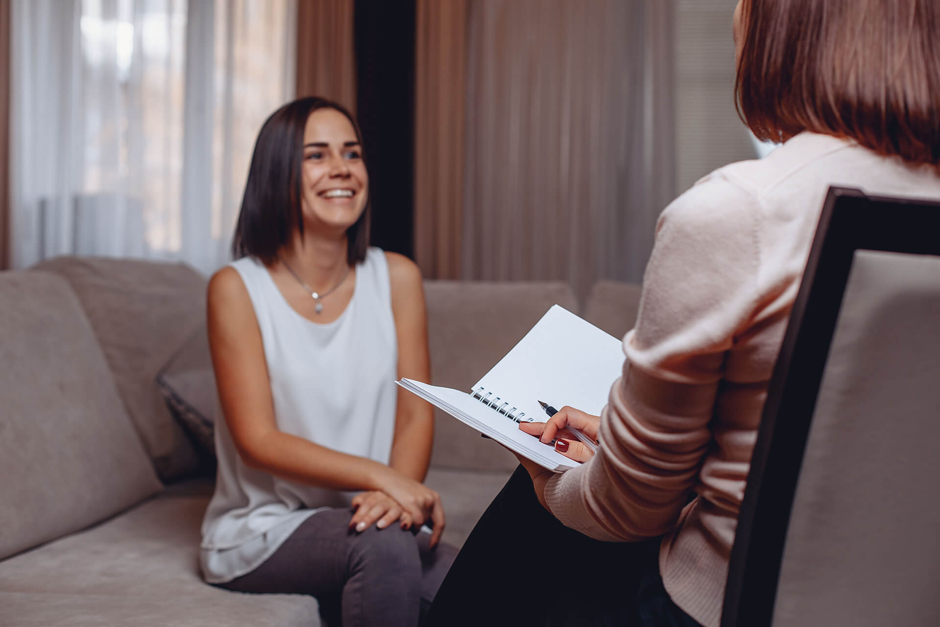Therapist and client share a smile during an online Cognitive Behavioral Therapy (CBT) session for eating disorders like anorexia, bulimia, and binge eating disorder