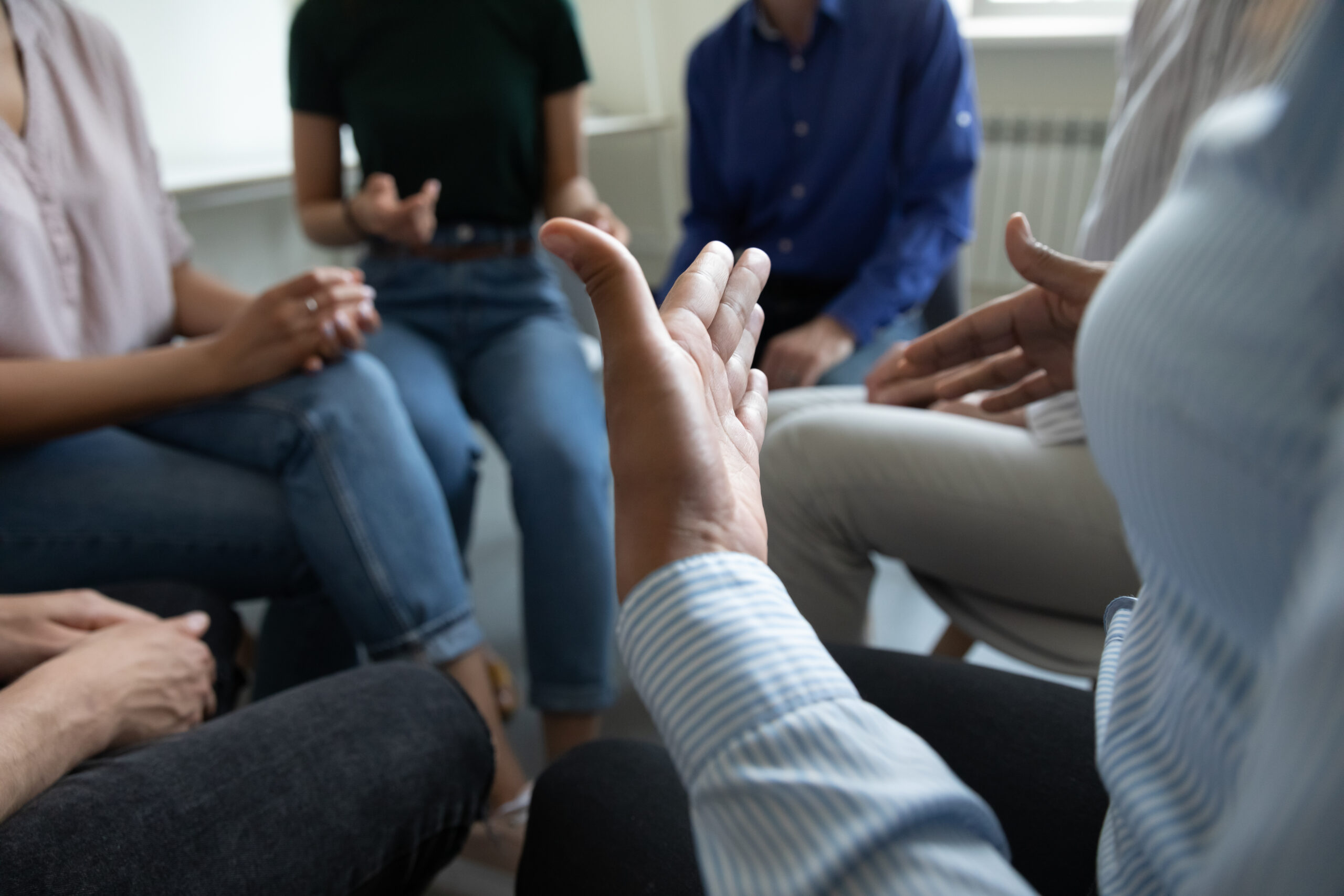 Close-up view of a diverse group sharing ideas during a support group session for eating disorders