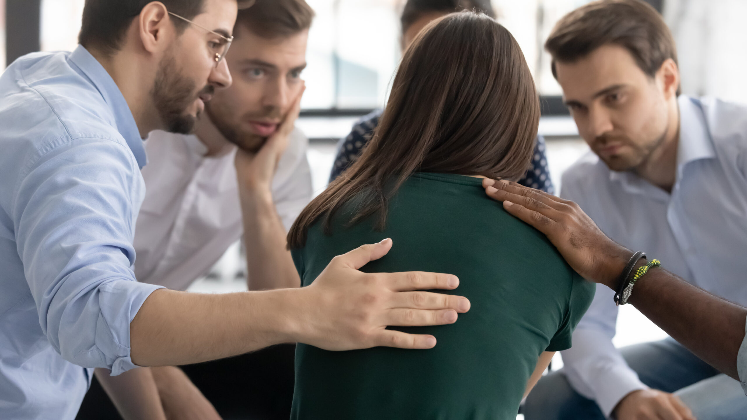 Support team consoling a woman during a group eating disorder therapy session